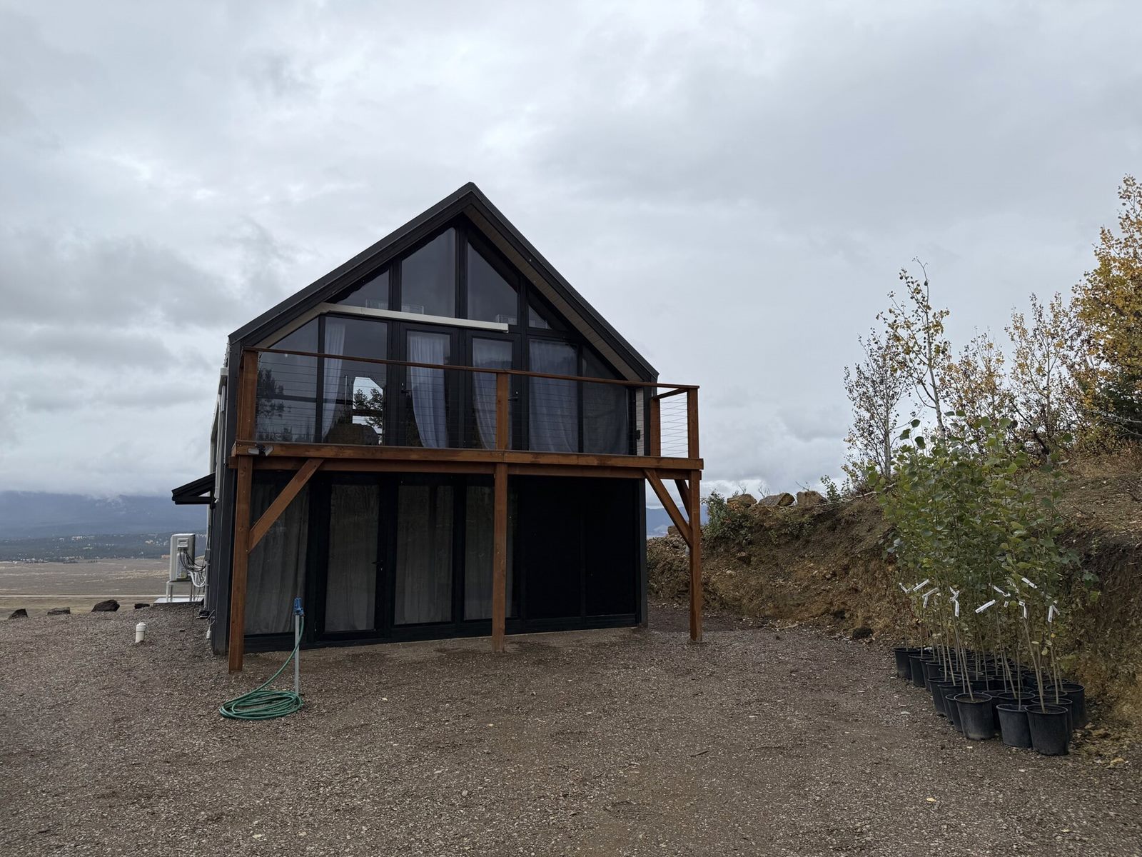Rear elevation of a completed Aries 116 cabin with a locally built upper wooden balcony in Island Park, ID.