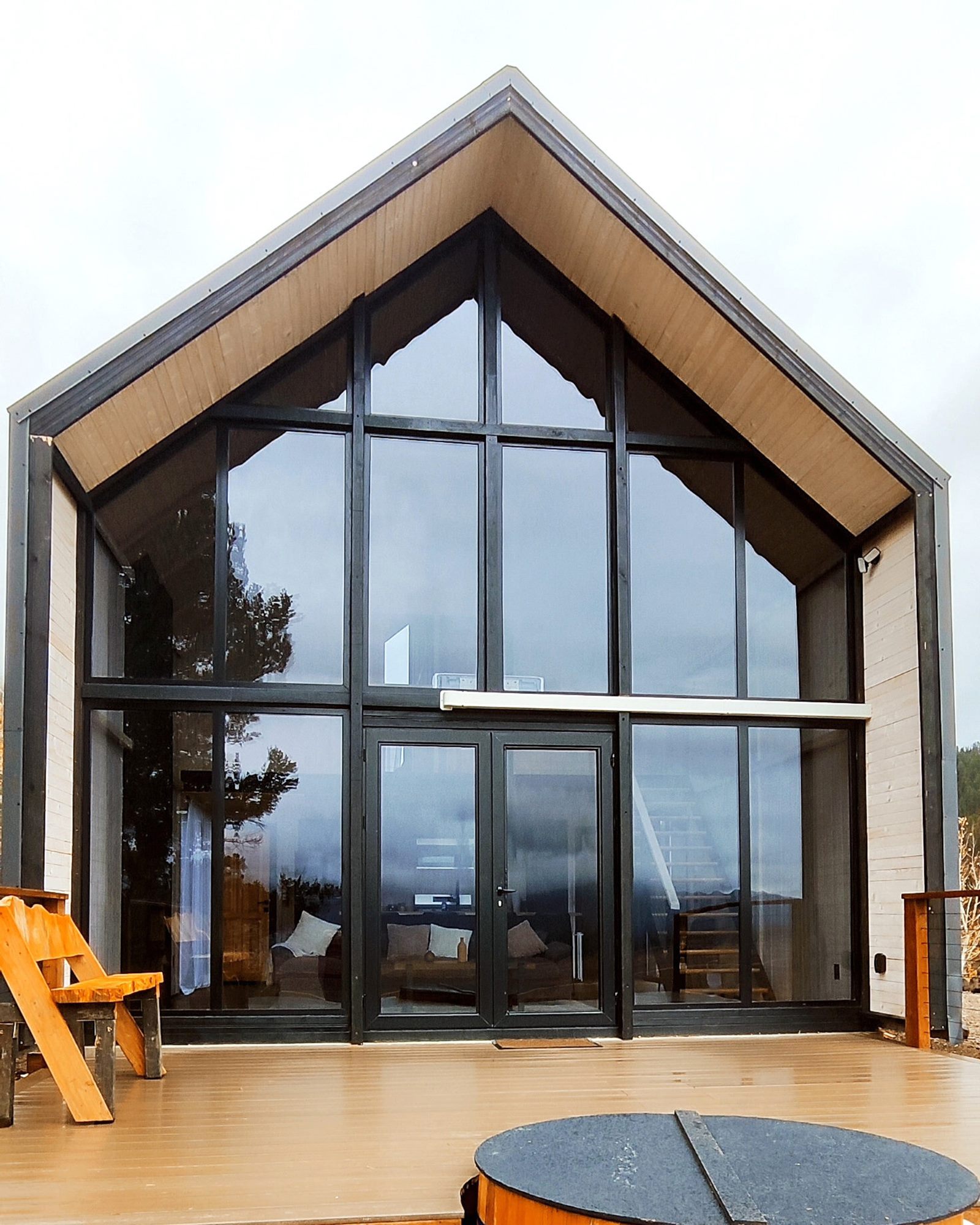 Front glass facade of a completed Aries 116 cabin beside the locally completed deck area in Island Park, ID.