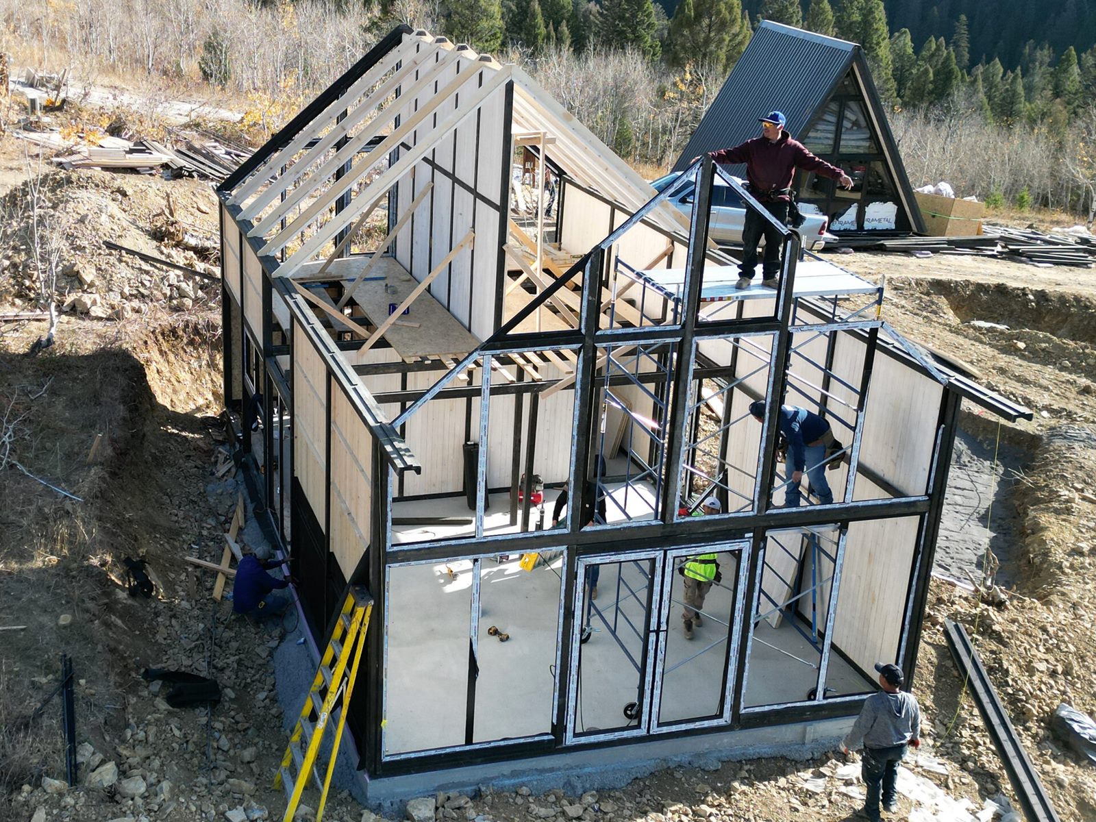 Aerial view of an Aries 116 cabin with open wall and roof framing during construction in Island Park, ID.