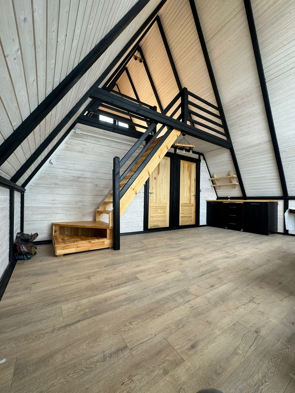 Open Stella 70 interior with timber loft and black structural frame. Earlier Stella 70 application; project finishes and amenities vary.