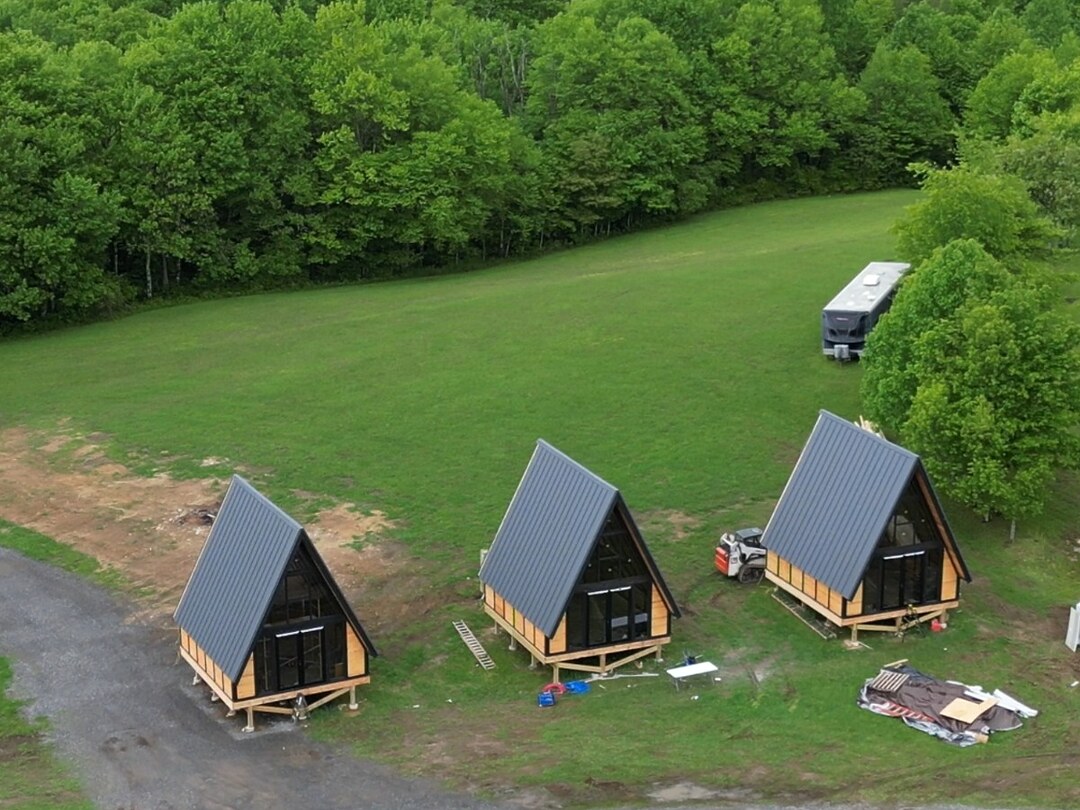 Aerial view of three Stella 70 A-frame cabins nearing exterior completion at WV ATV Resort