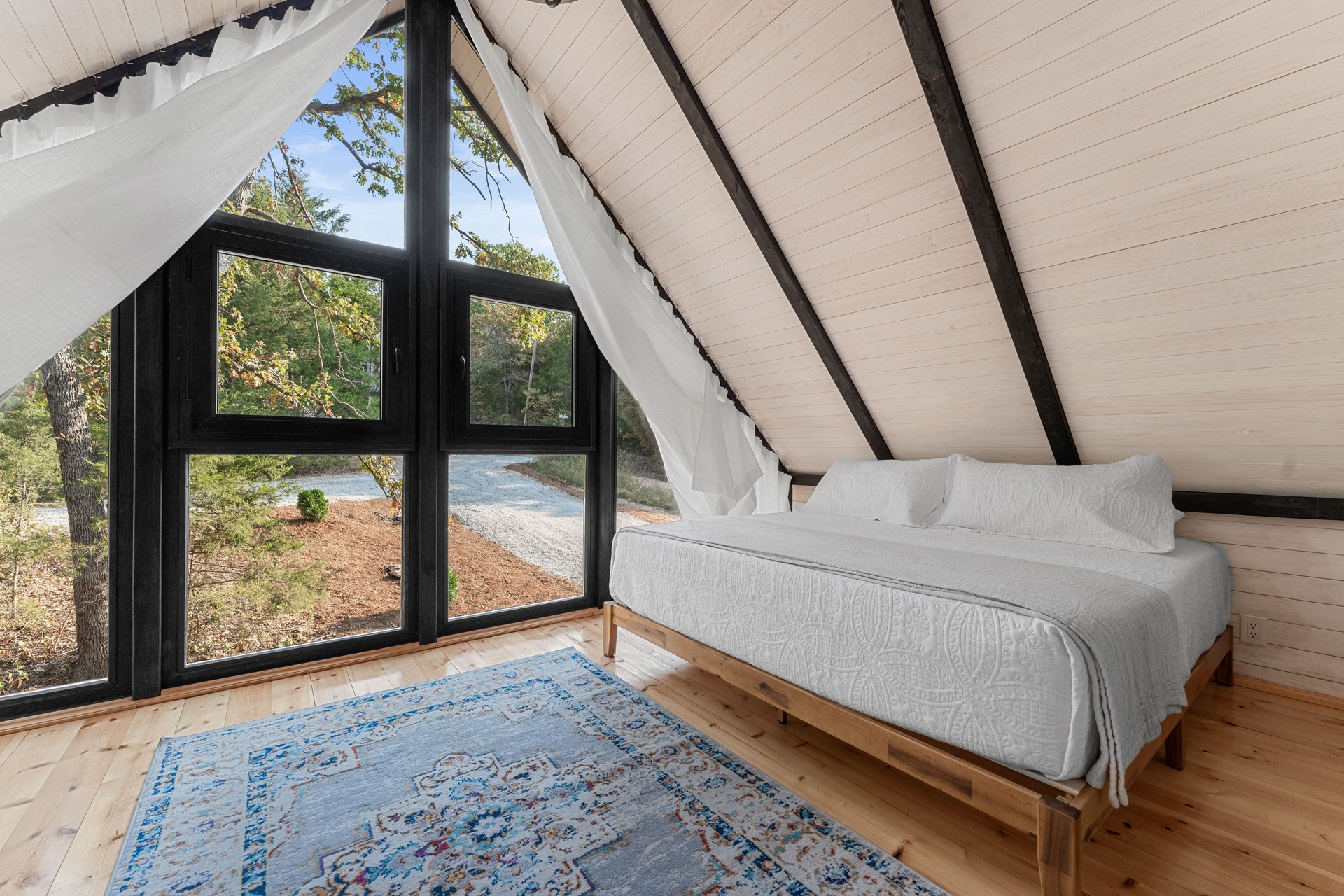 Loft twin bedroom facing glazing at the Aries 96 cabin project in Omaha, Arkansas.