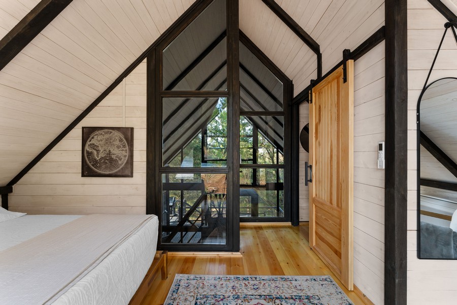 Loft bedroom and railing inside the completed Aries 96 cabin in Omaha, Arkansas.