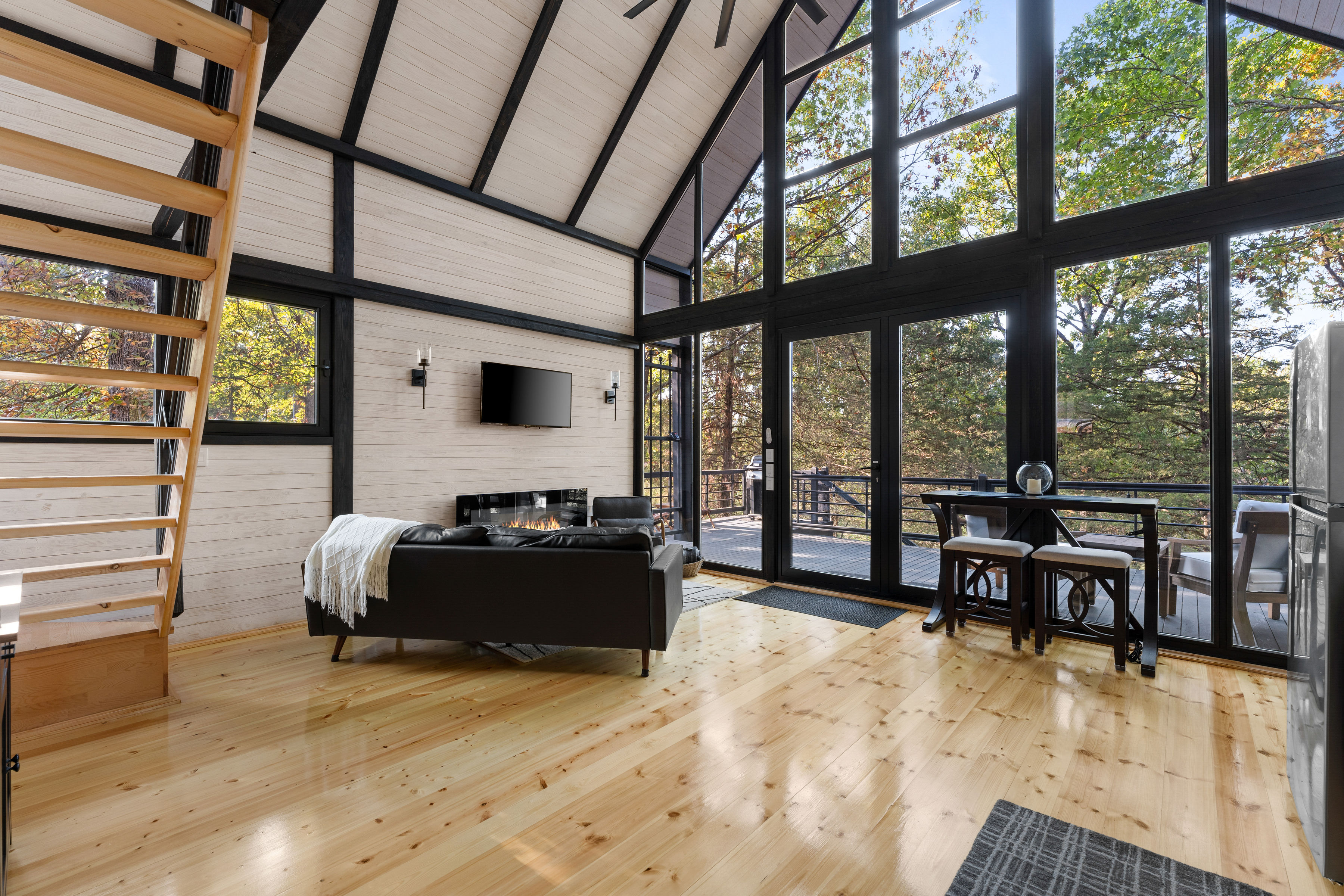 Completed Aries 96 living room with panoramic glazing and views of the Arkansas forest.