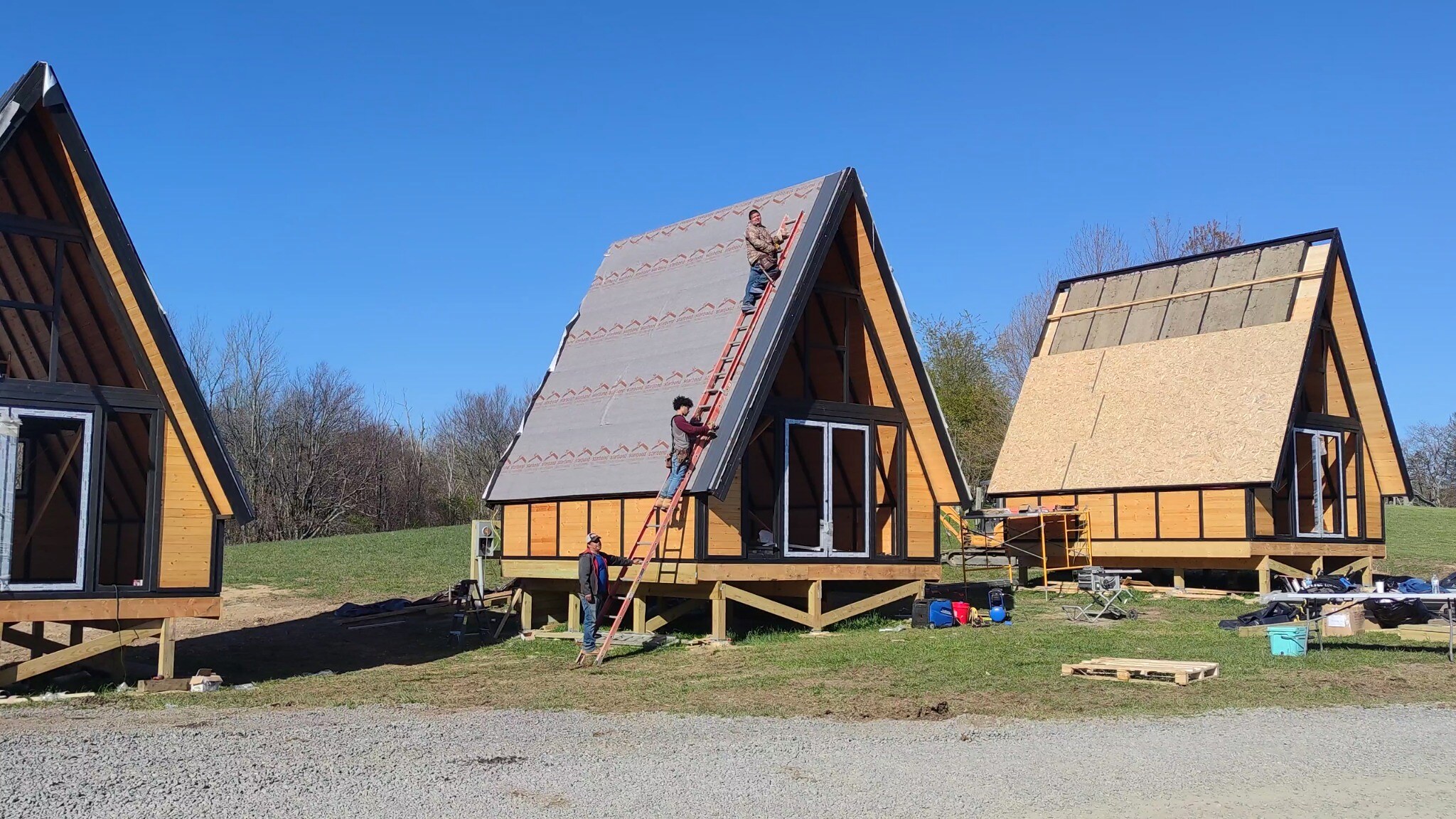 Crew installing roof membrane and insulation on Stella 70 A-frame cabins at WV ATV Resort