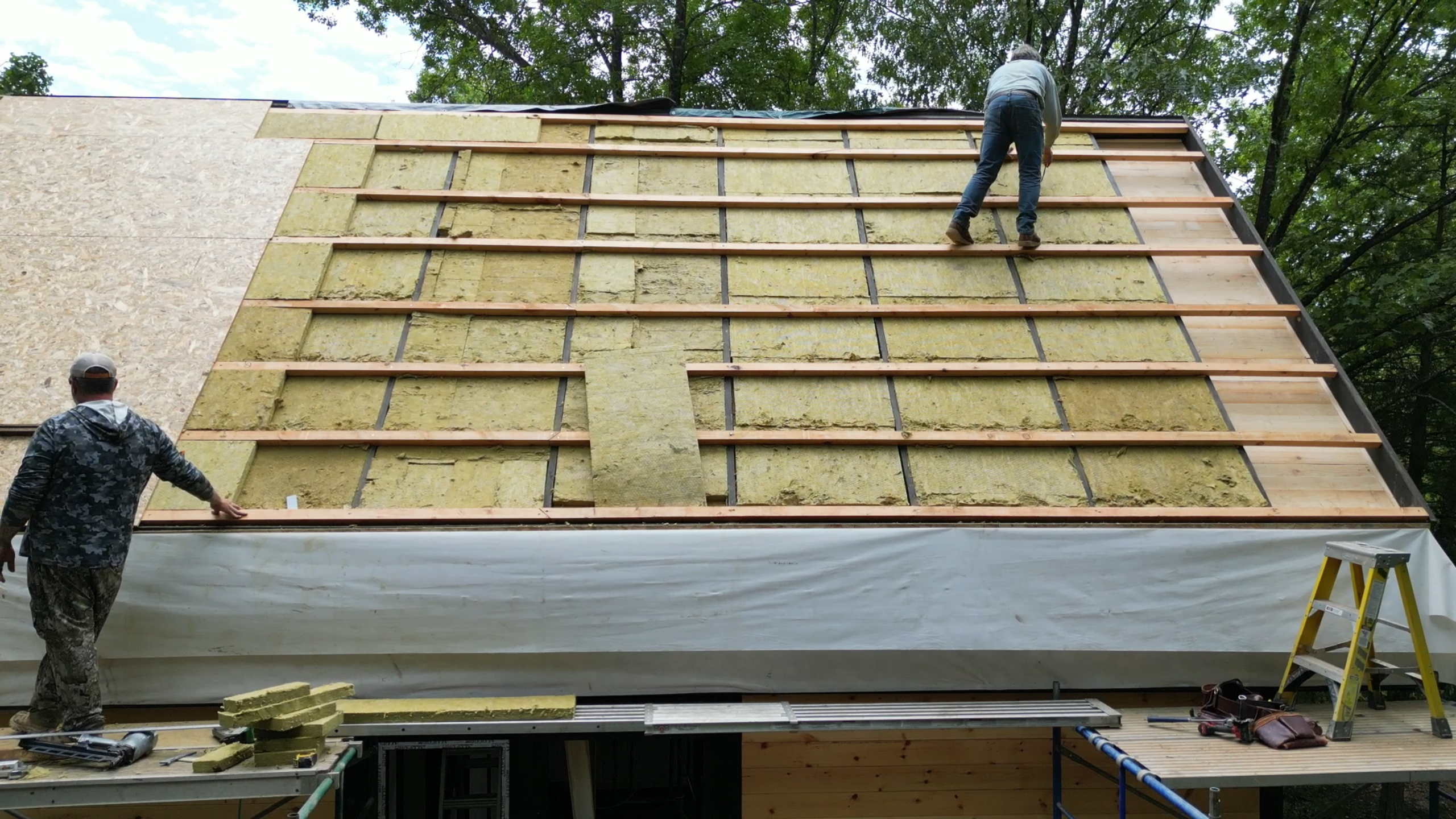 Layered roof insulation installation on the Arkansas Aries 96 cabin.