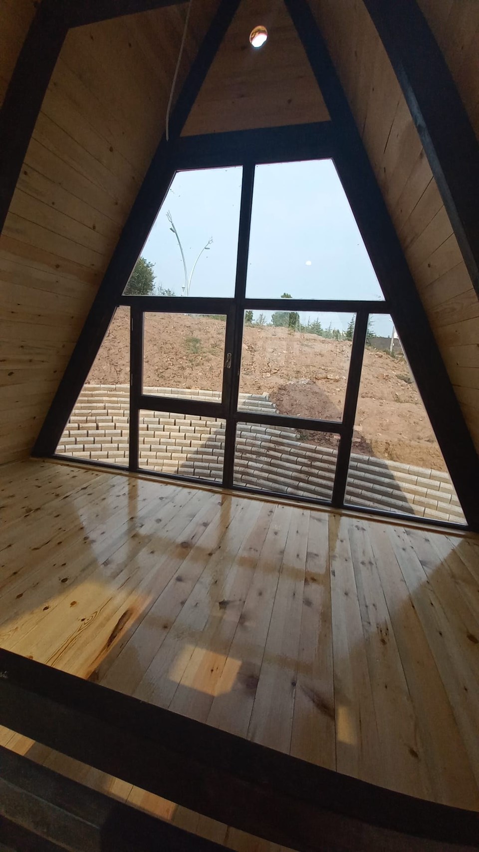 Loft interior facing the full-height triangular window. Kocaeli / Earlier Stella 70+ revision.