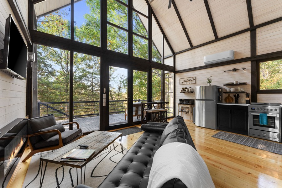 Open-plan living room with the kitchen visible in the completed Aries 96 cabin in Omaha, Arkansas.
