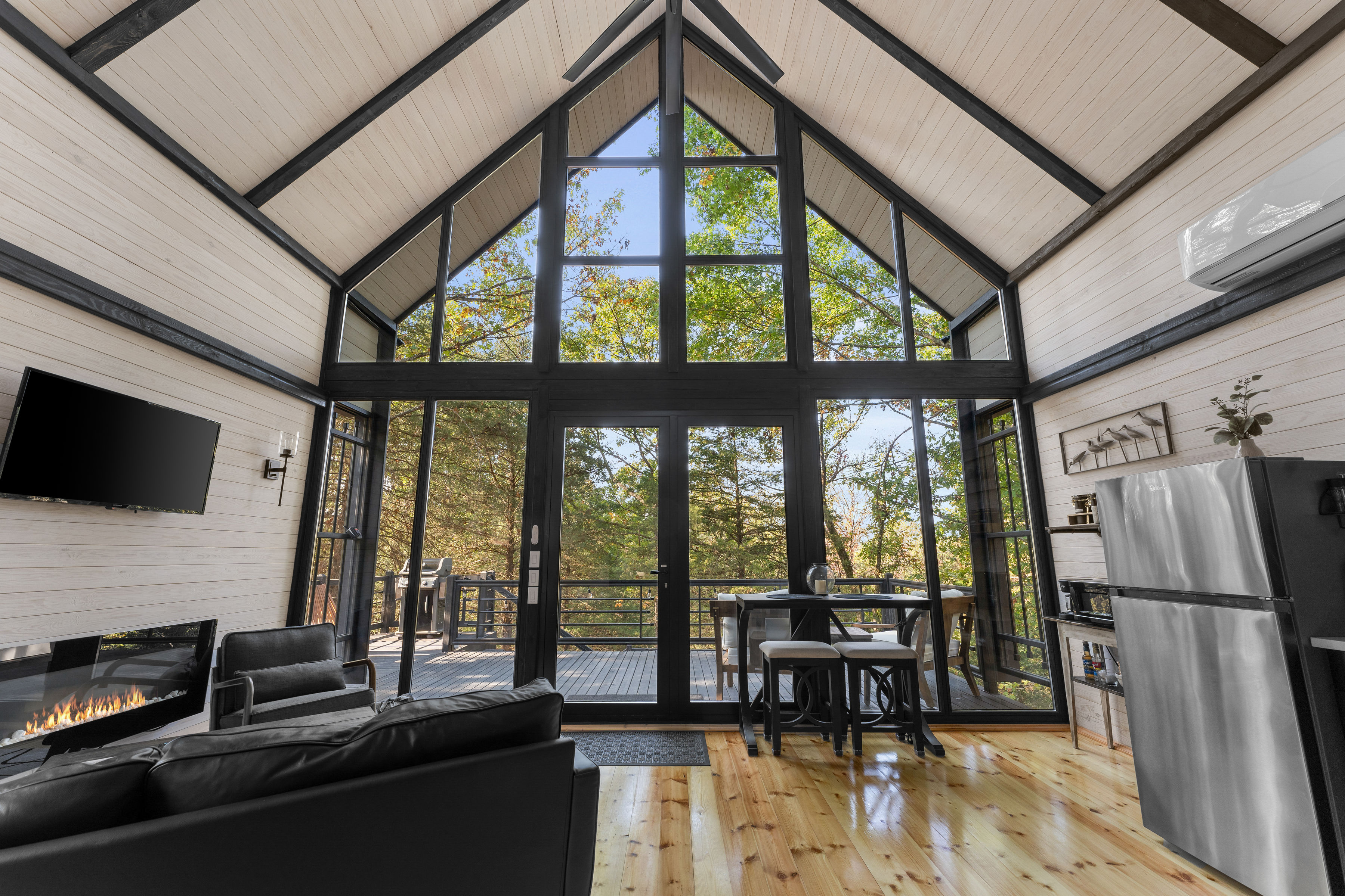 Finished Aries 96 interior facing the panoramic glass wall and forest view.