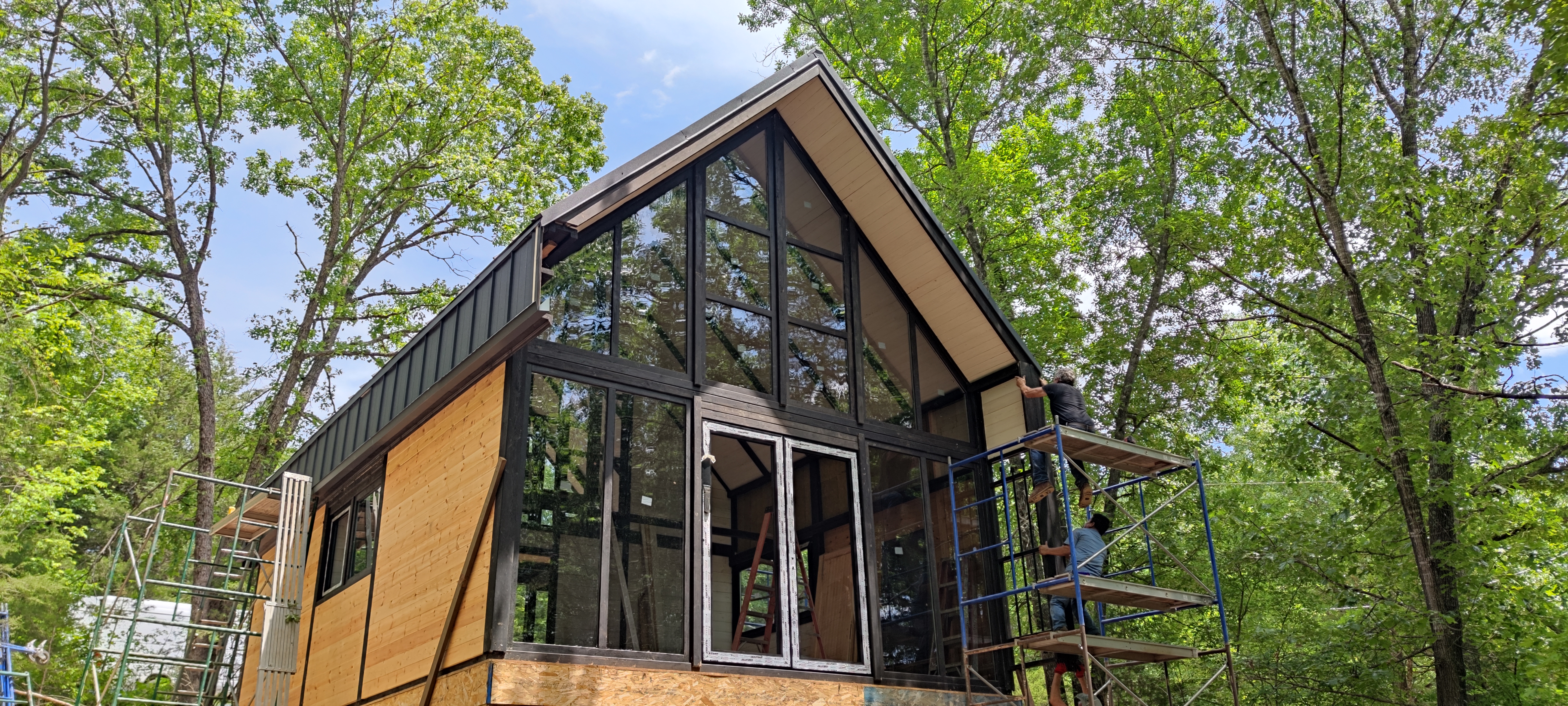 Arkansas Aries 96 cabin with panoramic front glazing and exterior work in progress.