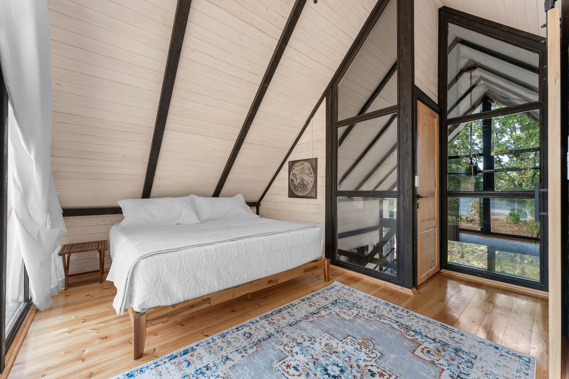 Loft bedroom with glass partition inside the completed Aries 96 cabin in Arkansas.