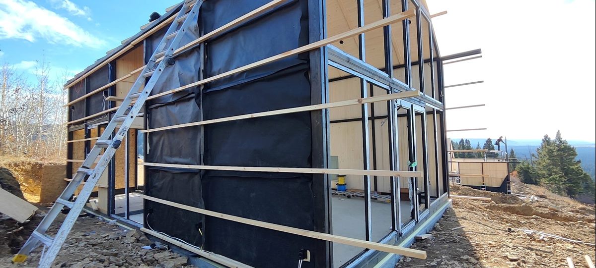 Side and front corner of an Aries 116 cabin with exterior battens during construction in Island Park, ID.