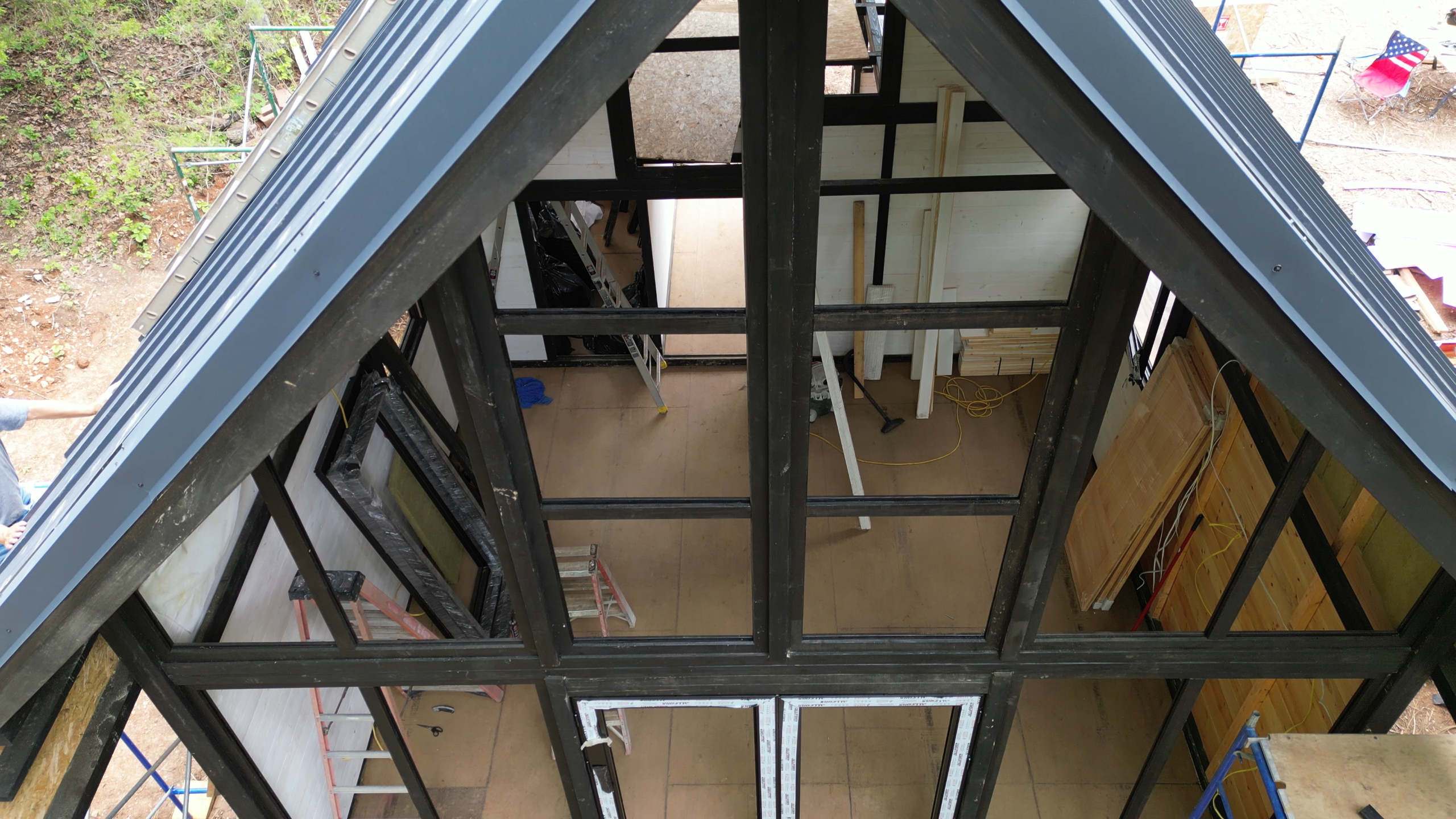 Aerial view of roof framing and interior plank installation during the Arkansas Aries 96 cabin build.