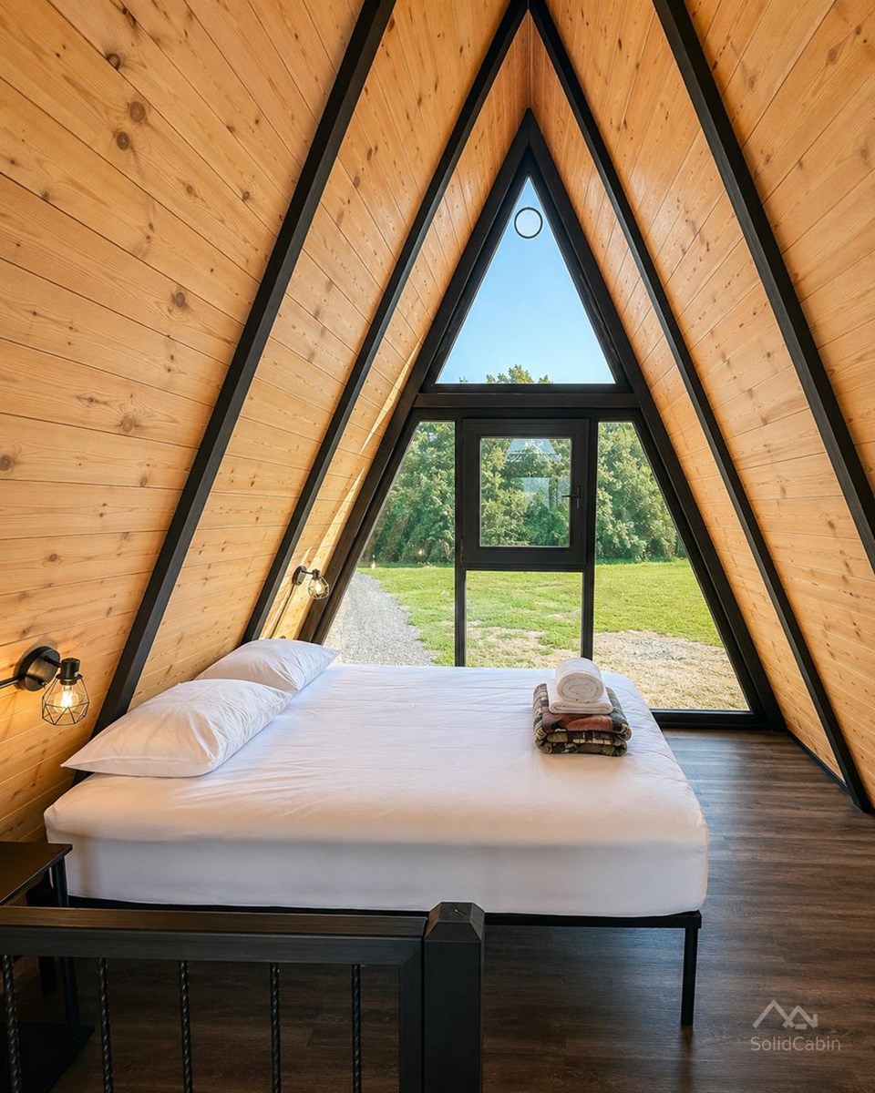 Sleeping area with triangular glazing in an earlier West Virginia cabin.