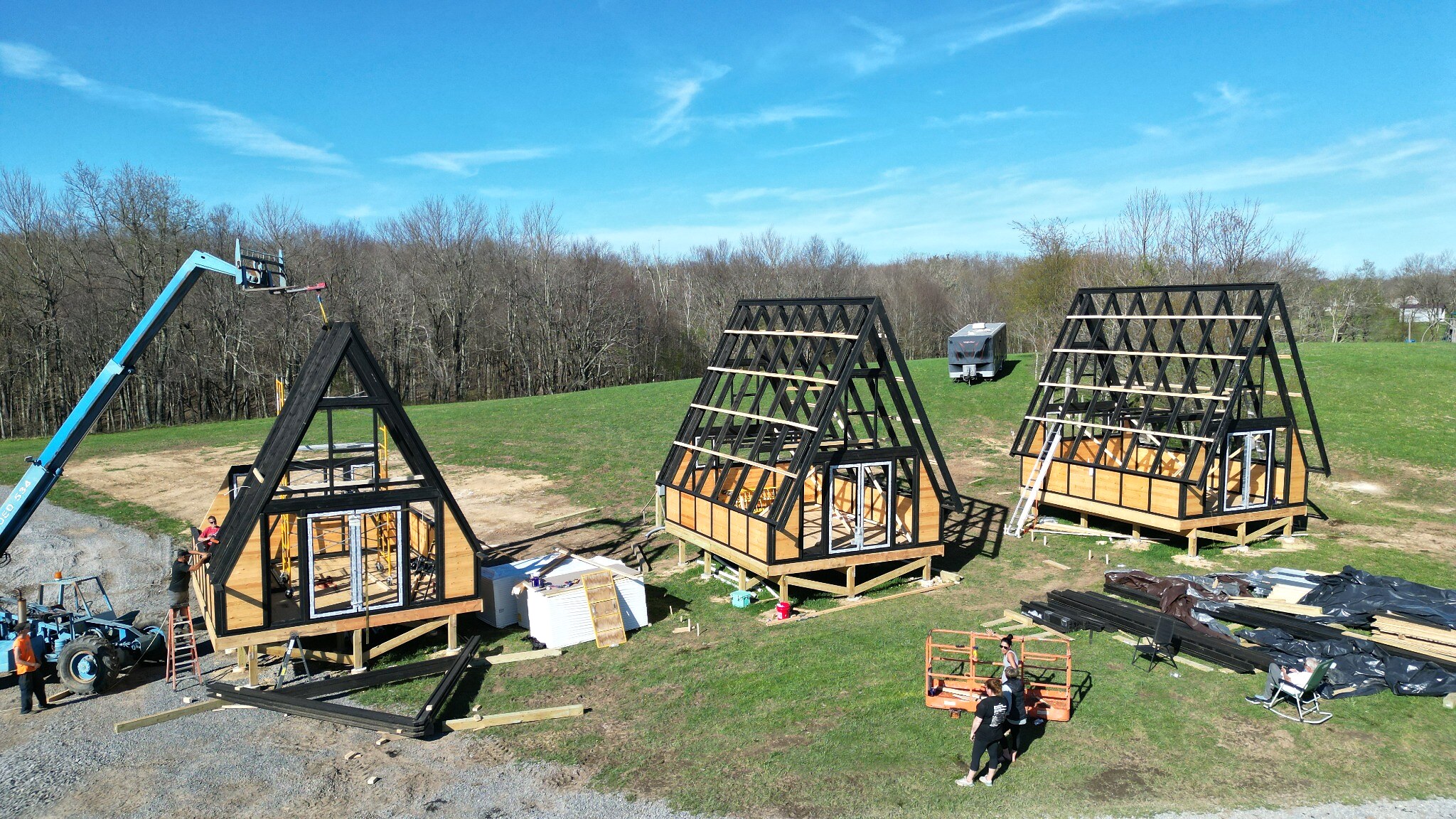 Three Stella 70 A-frame cabin structures standing after framing at WV ATV Resort