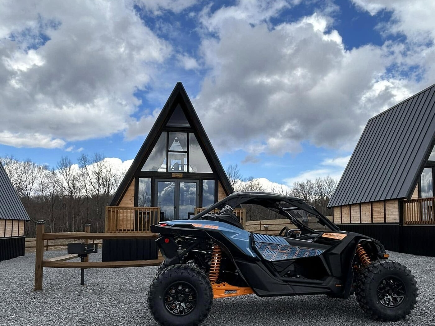 UTV parked in front of Stella 70 A-frame rental cabins at WV ATV Resort.