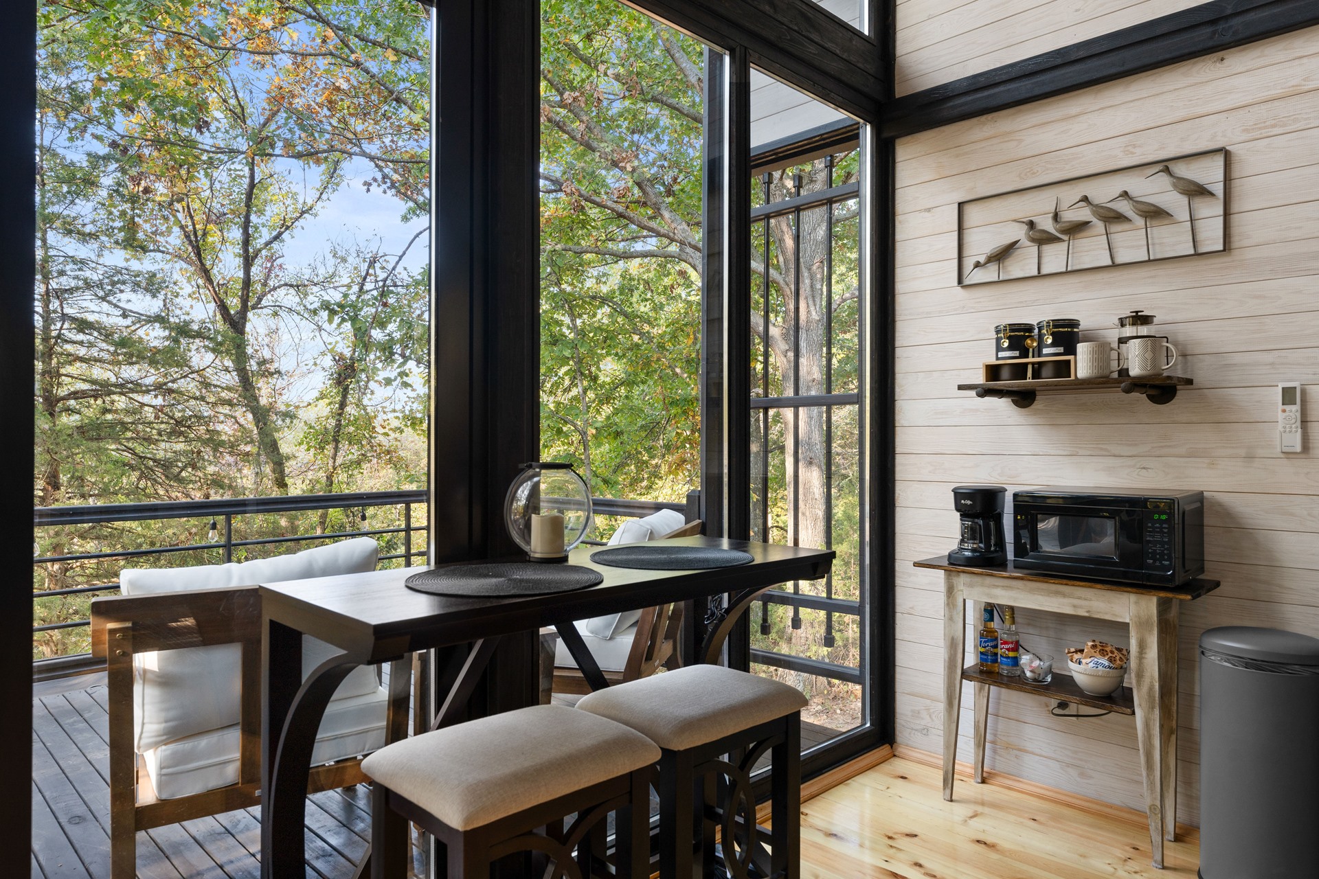 Dining area beside the full-height glazing in the completed Aries 96 cabin in Omaha, Arkansas.