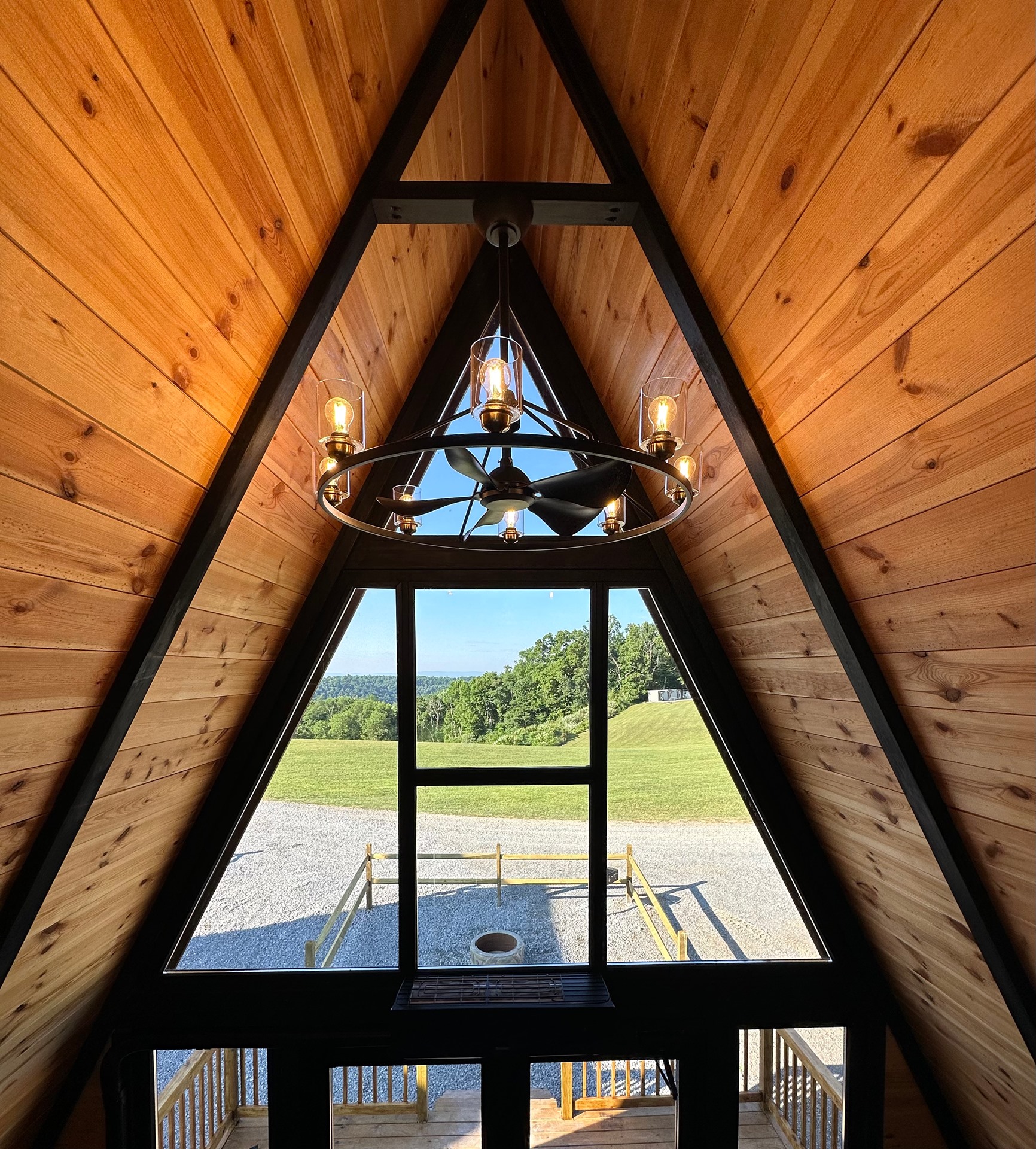 Stella 70 loft interior with triangular window and chandelier at WV ATV Resort.