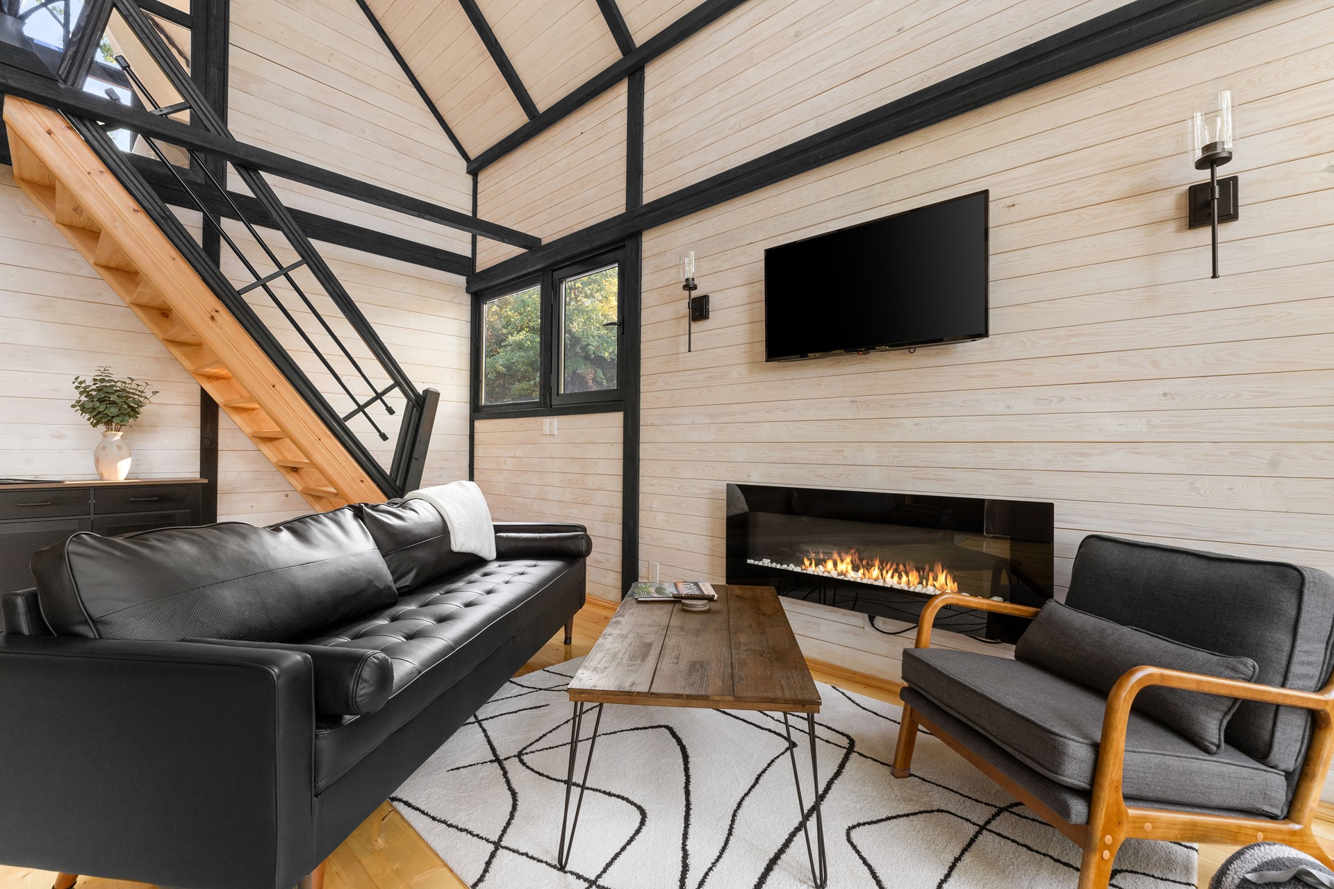 Living room with fireplace and staircase in the completed Arkansas Aries 96 cabin.