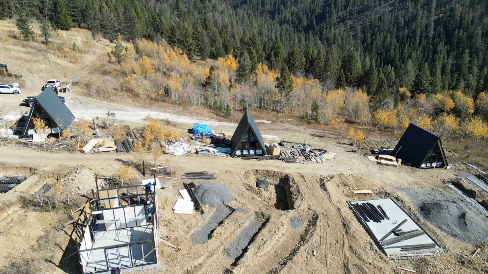 Aries 116 and Stella 53 cabins at different construction stages across the Island Park property.