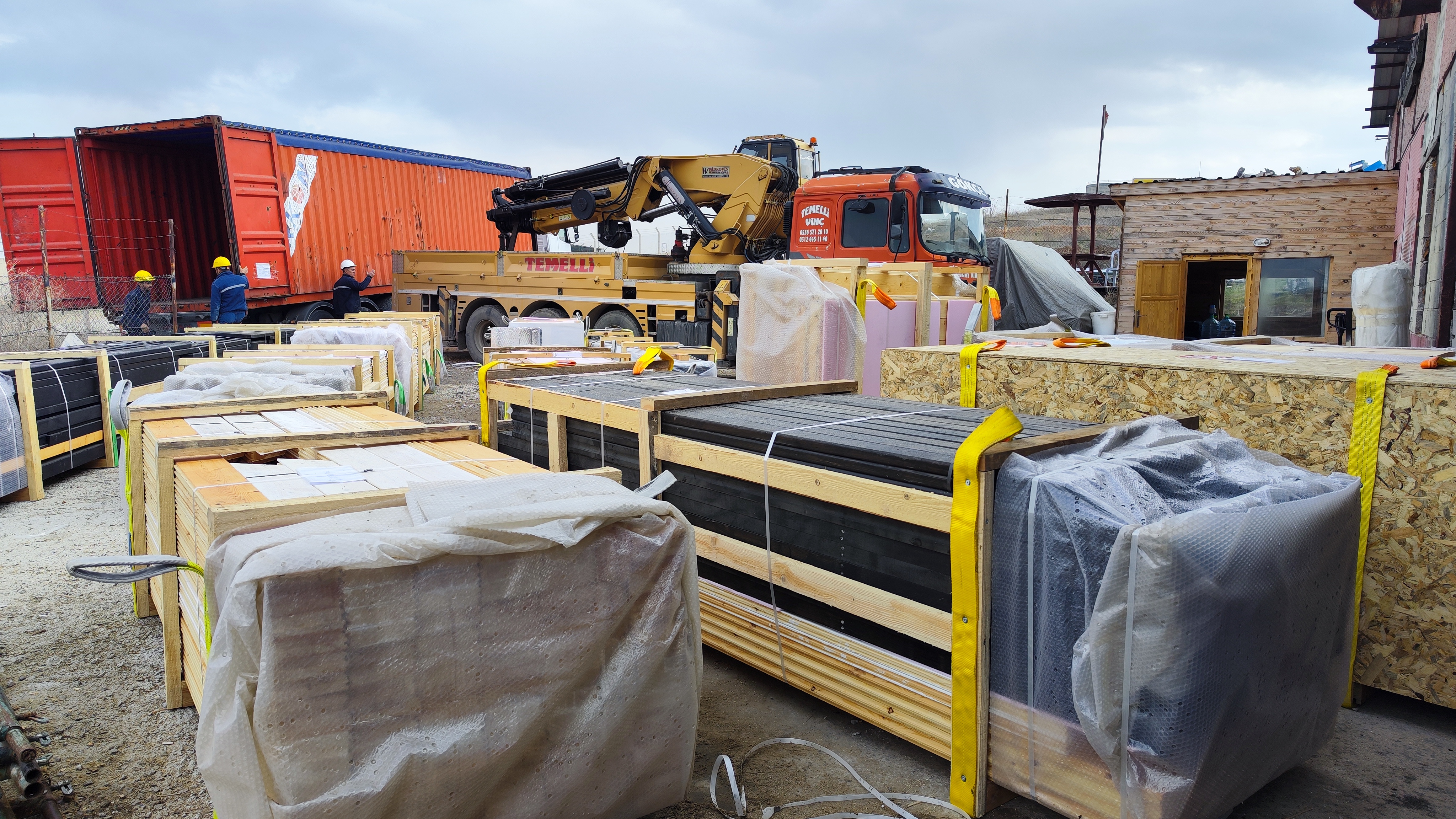 Wrapped Aries 96 cabin-kit packages staged before container loading.