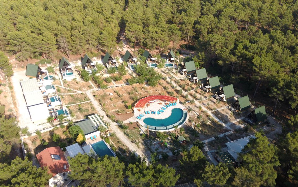 Aerial view of the completed cabin resort and shared outdoor areas. Site amenities are locally provided.