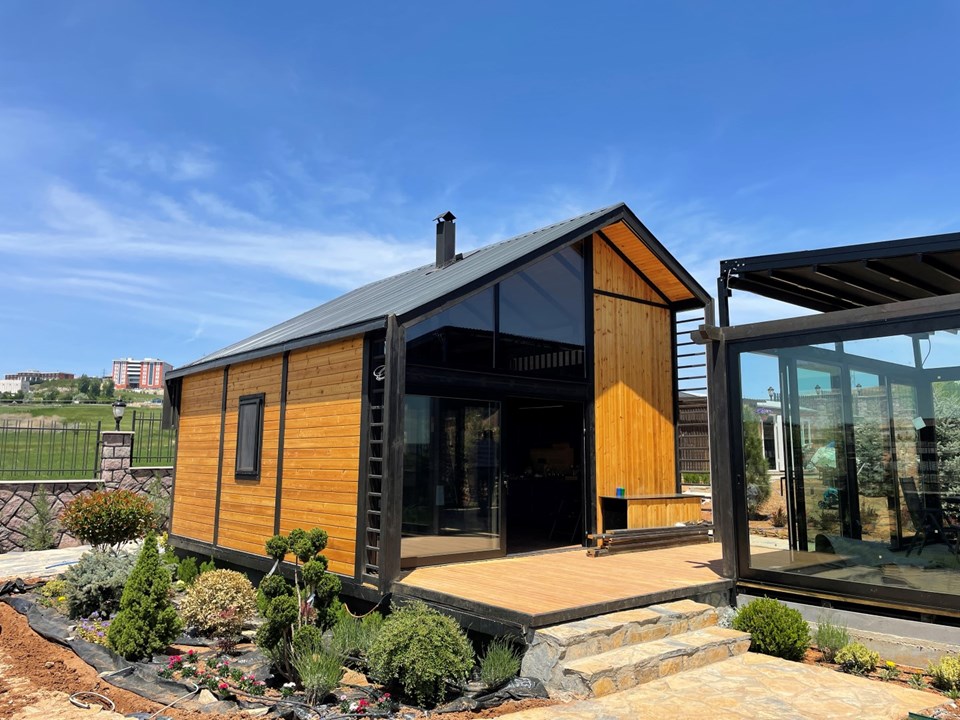 Completed Libra 72 front elevation with tall glazing and an outdoor deck in İncek.