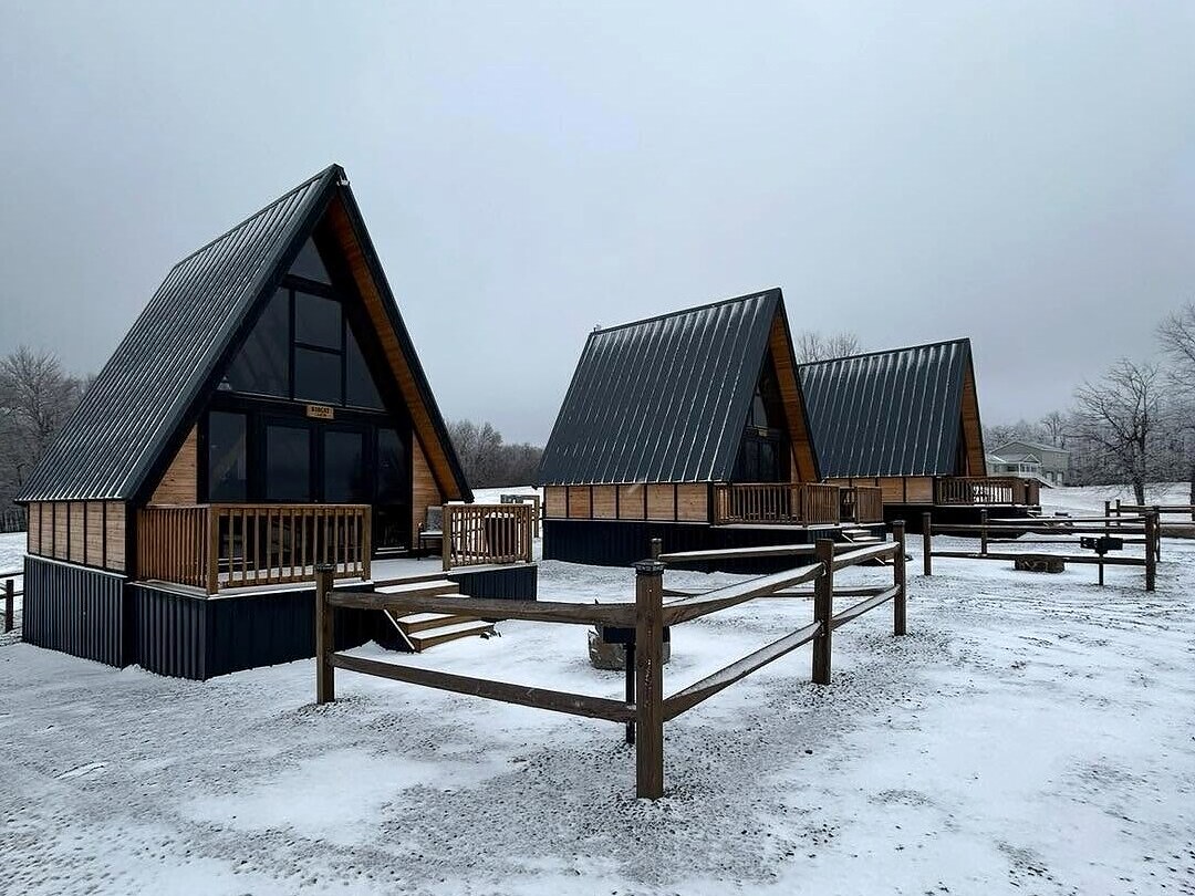 Three completed Stella 70 A-frame cabins in winter at WV ATV Resort in West Virginia