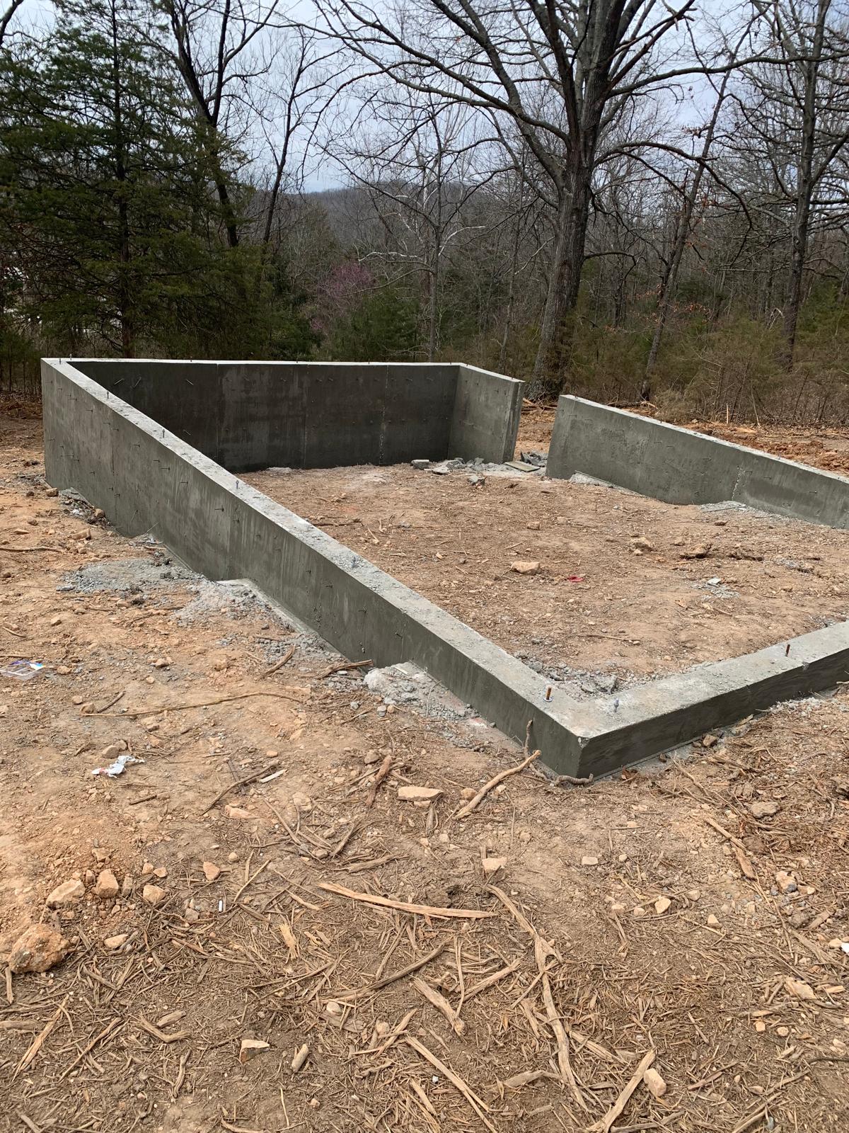 Concrete crawl-space foundation prepared for the Arkansas Aries 96 cabin on the sloped Ozarks site.