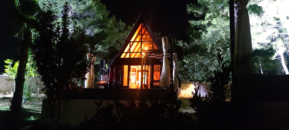 Illuminated Stella 70 cabin exterior at night. Earlier Stella 70 application; project finishes and amenities vary.