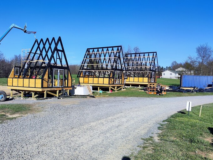 Three Stella 70 A-frame cabin kits during structural assembly at WV ATV Resort in West Virginia