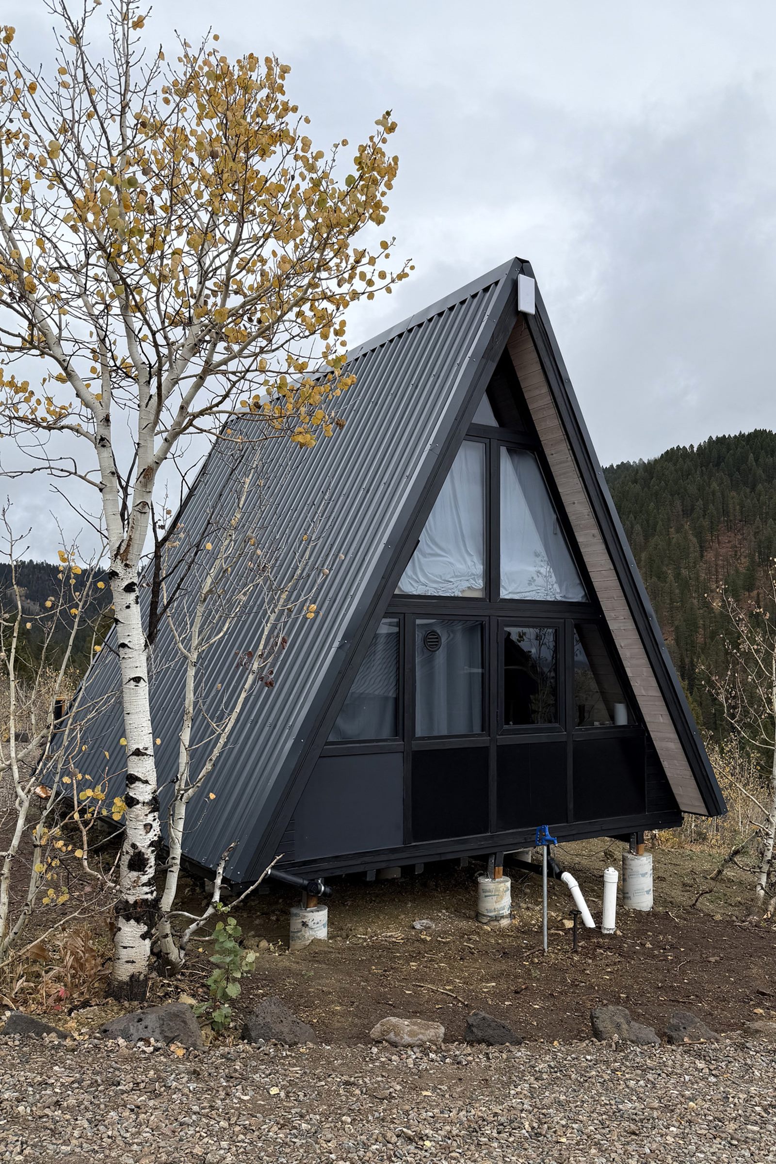Completed Stella 53 A-frame cabin beside aspen trees at the Island Park, ID hospitality project.