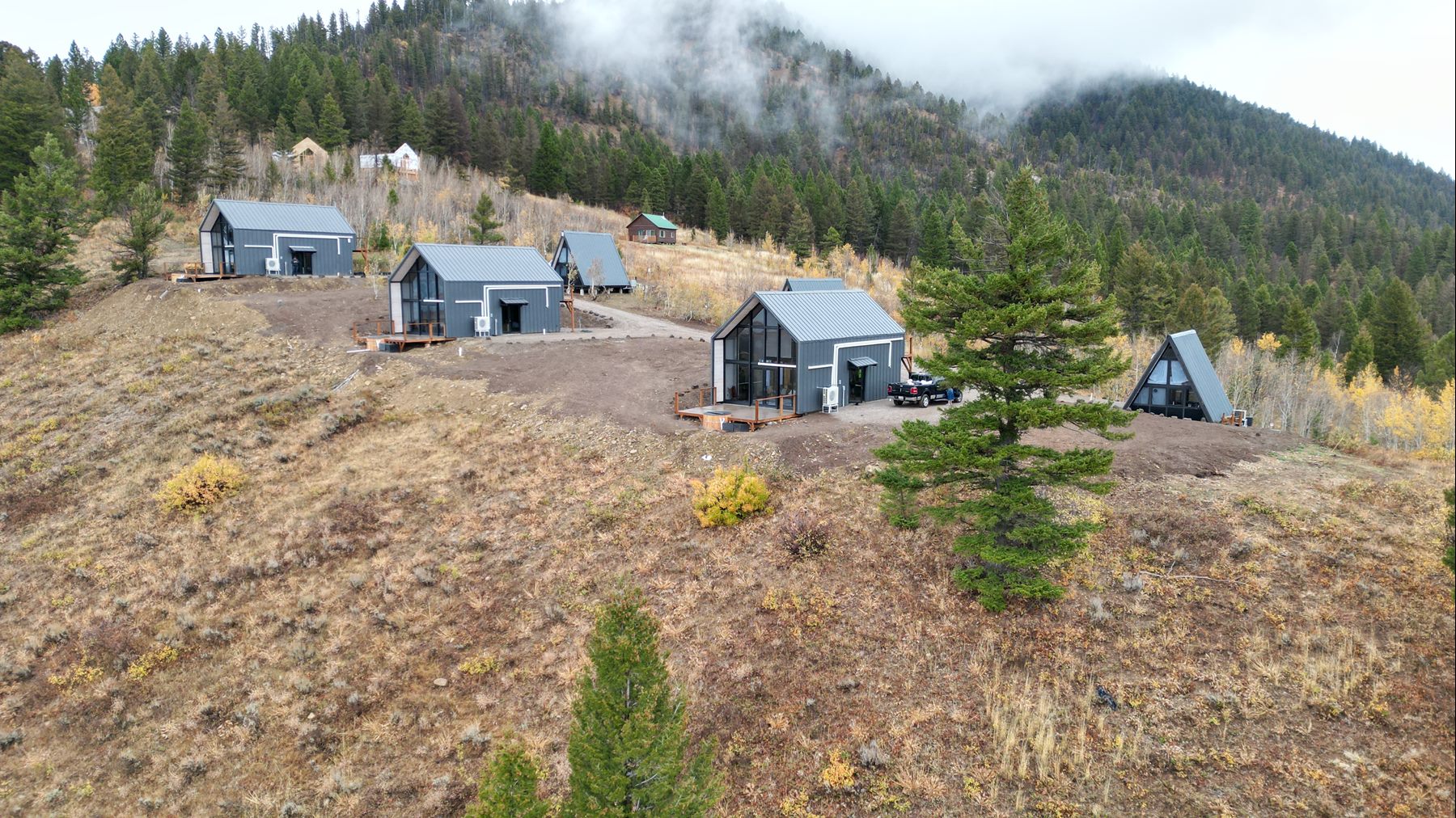 Aerial view of the completed three Aries 116 and three Stella 53 cabins on the Island Park, ID rental property.