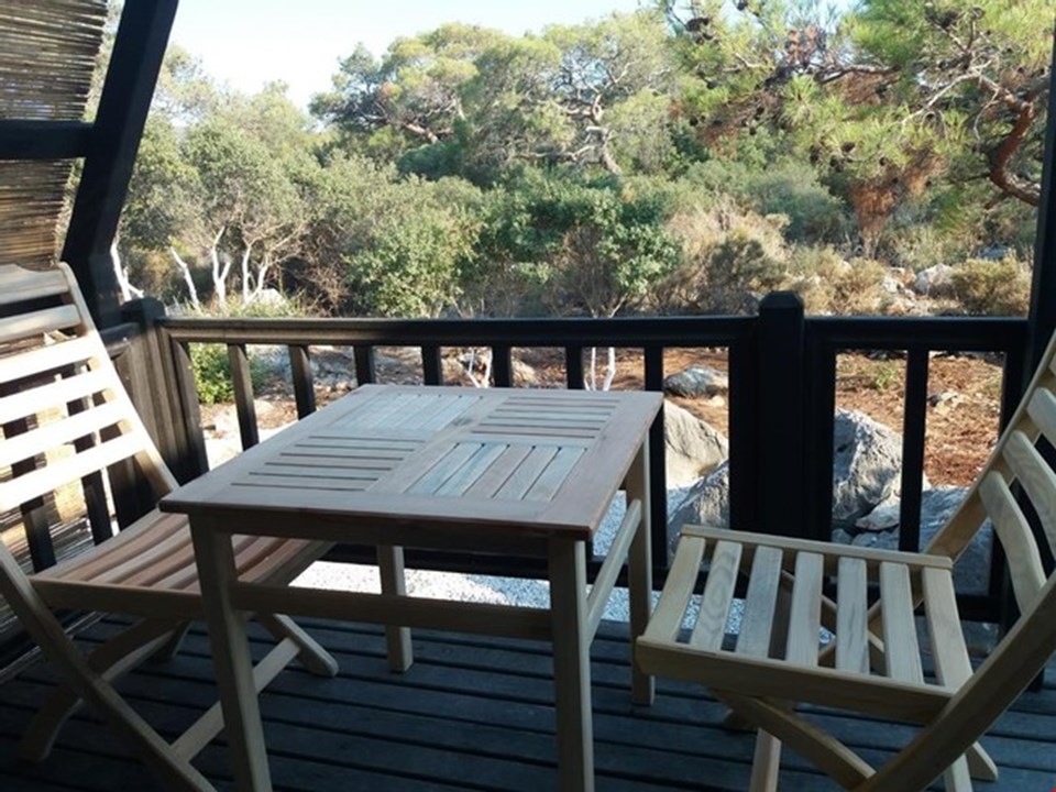 A timber deck furnished for outdoor dining at a Stella 34 cabin.