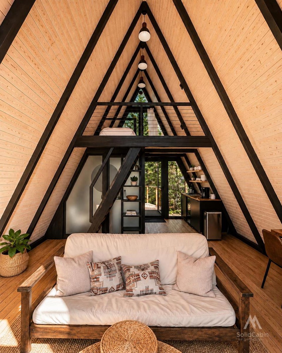 Furnished Stella 53 interior with an open living space, loft and triangular glazing.