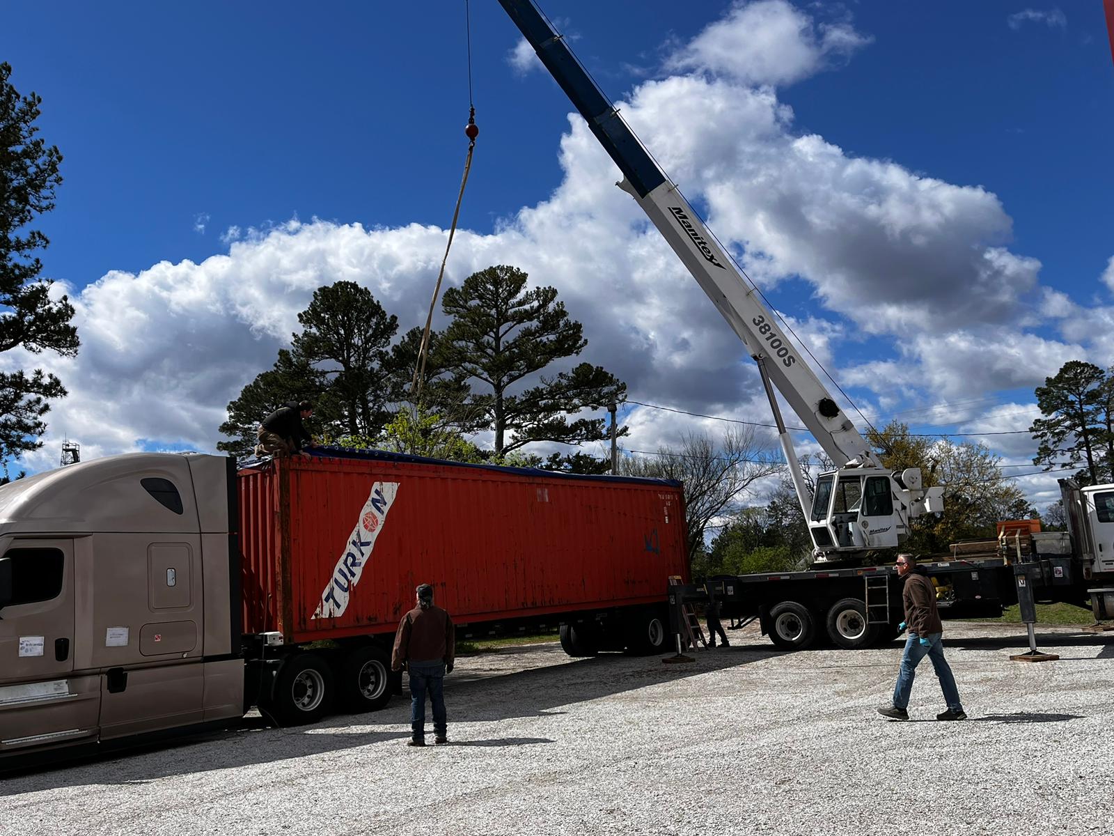 Open-top shipping container being unloaded by crane for the Arkansas Aries 96 project.