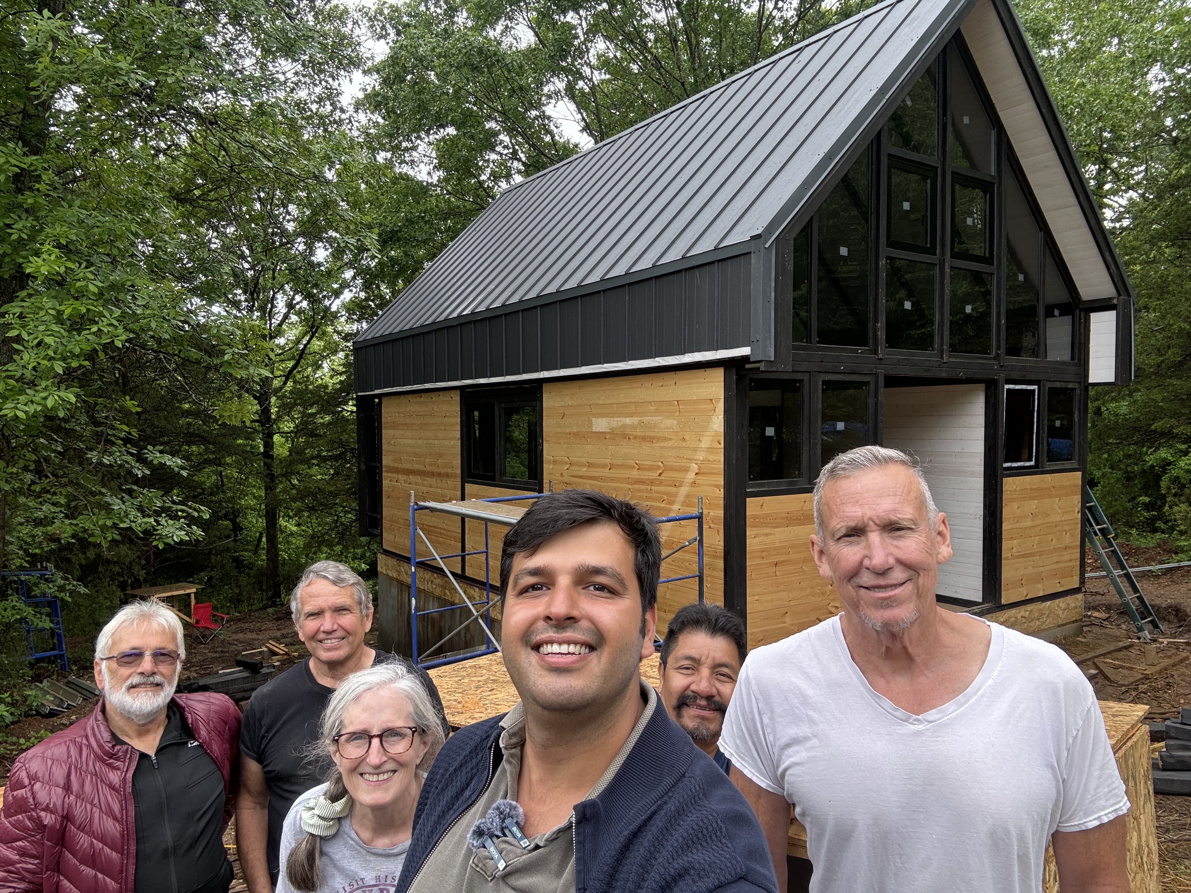 Owners, build crew and the SolidCabin guidance team together on site beside the Aries 96 cabin during construction in Arkansas.