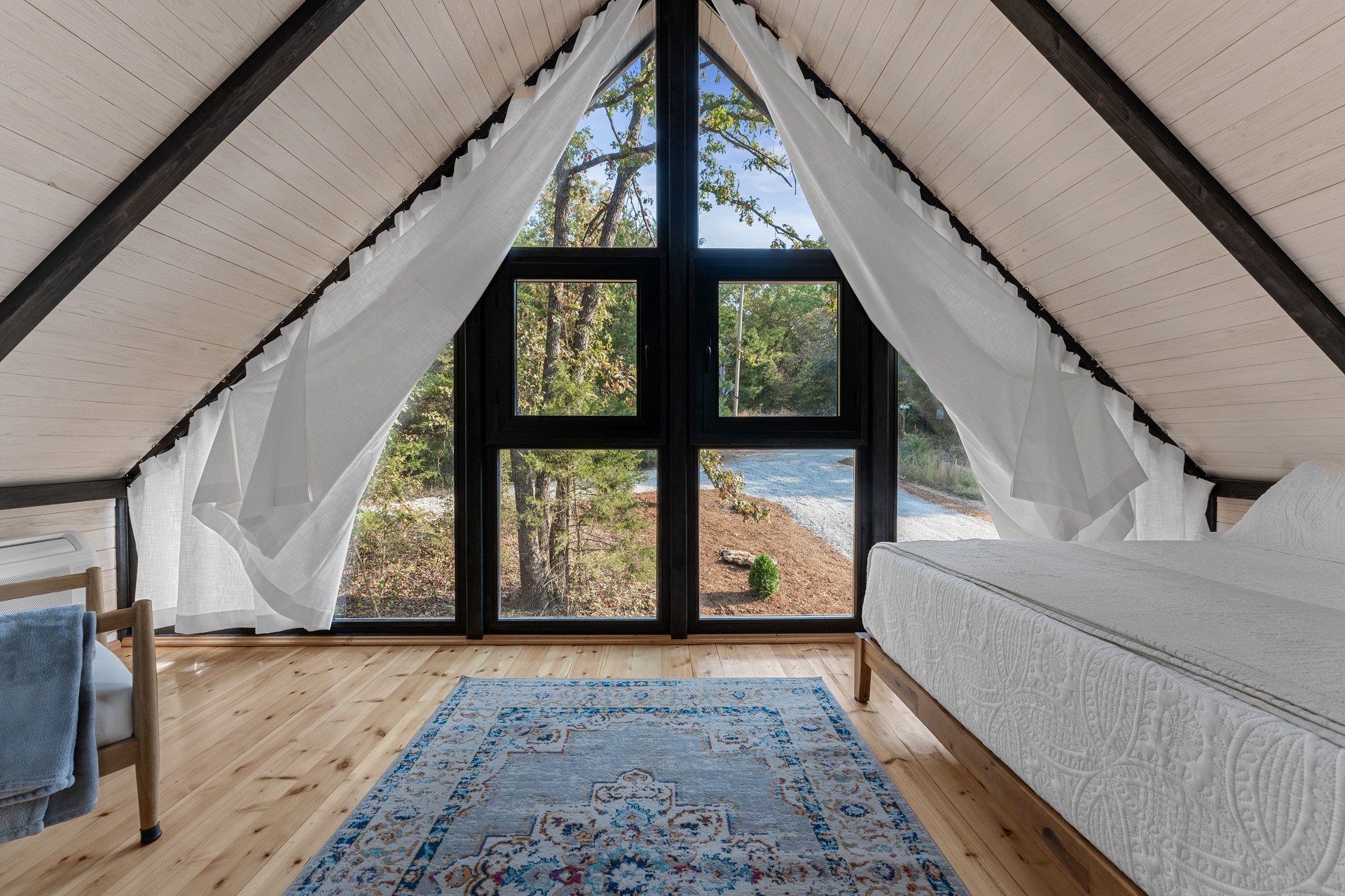 Loft twin bedroom facing glazing at the Aries 96 cabin project in Omaha, Arkansas.